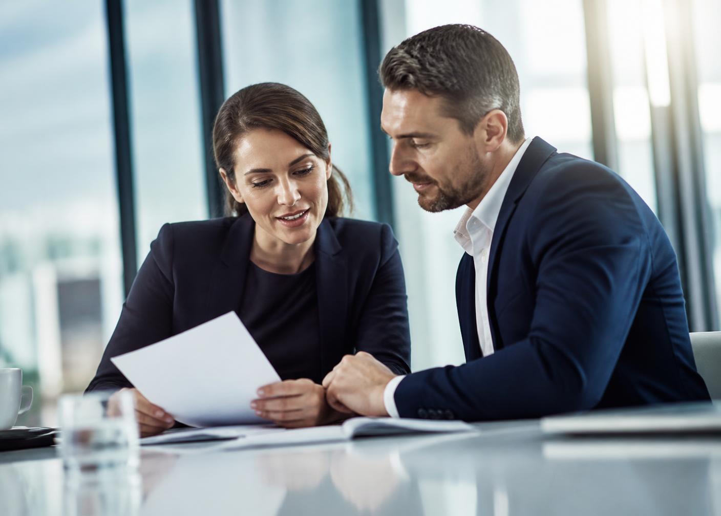 Two business professionals reviewing financing documents together